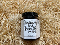 Jar of raspberry and vanilla jam on a bed of straw