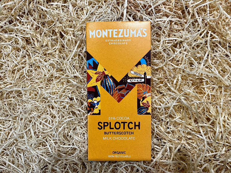 Montezuma's chocolate bar packaging on a natural straw background