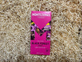Montezuma's Black Forest cherry dark chocolate bar packaging on a straw background