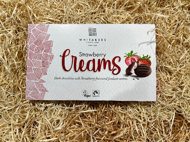 Whitaker's Strawberry Creams chocolate packaging on a straw background