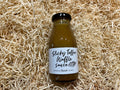 Bottle of Sticky Toffee Waffle Sauce on a bed of straw