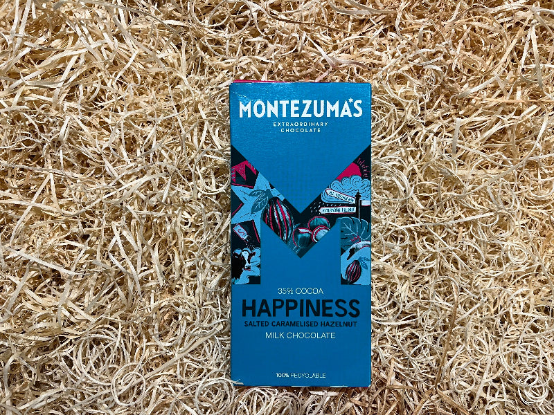 Montezuma's chocolate bar packaging on a natural straw background