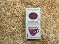 Box of gluten-free dark chocolate cookies on a bed of straw